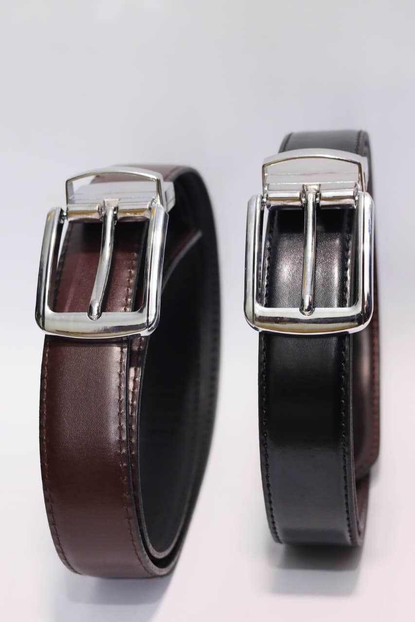 Two brown leather belts with silver buckles on a light gray background