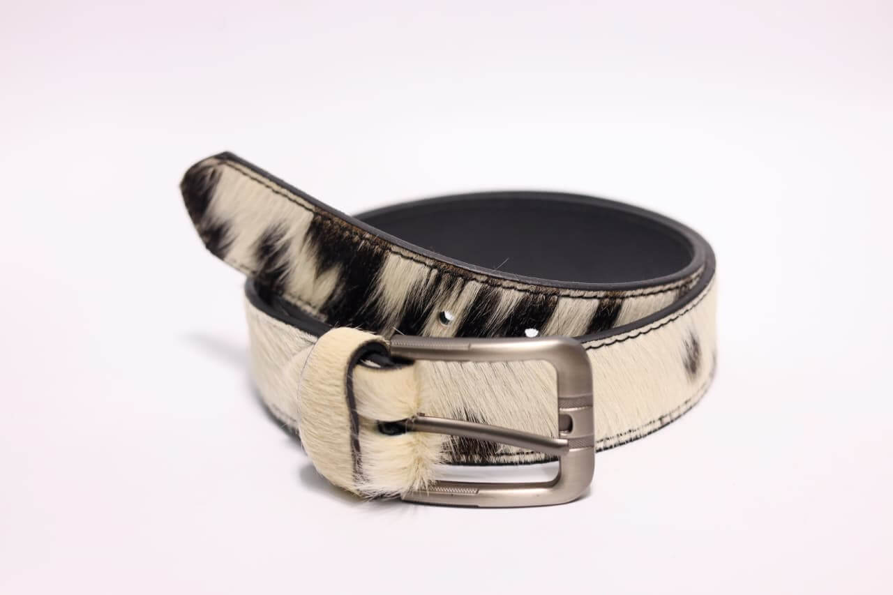Zebra print belt with a silver buckle on a light pink background