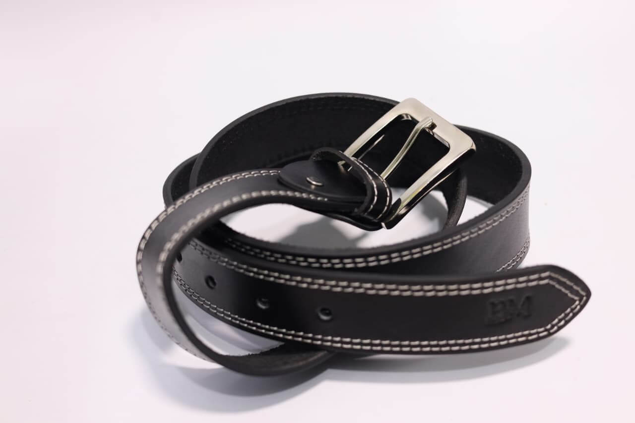 Black leather belt with silver buckle on a light gray background