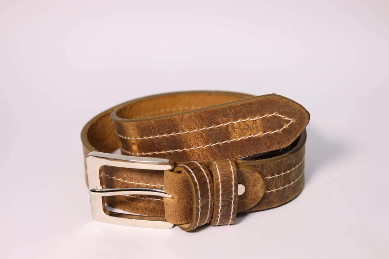 Brown leather belt with a silver buckle on a light gray background