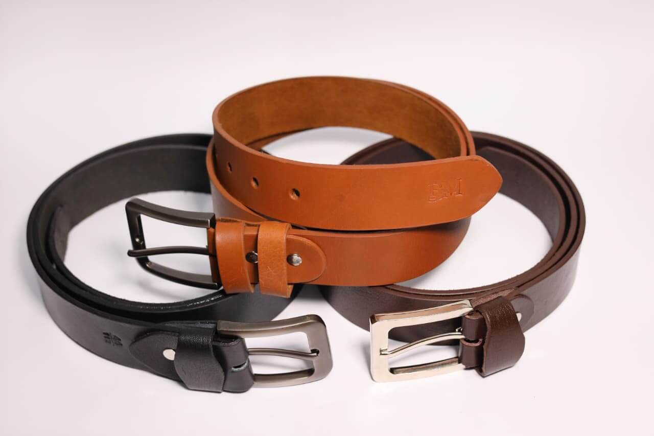 Three leather belts in black, brown, and another shade of brown on a white background.