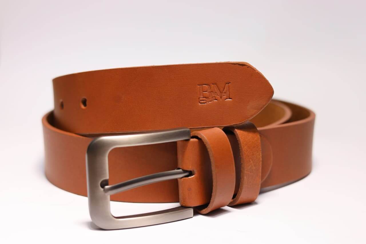 Brown leather belt with silver buckle on a white background