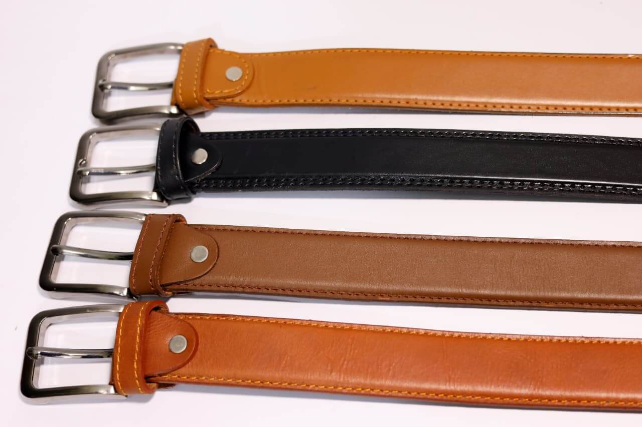 Three leather belts with metal buckles on a white background