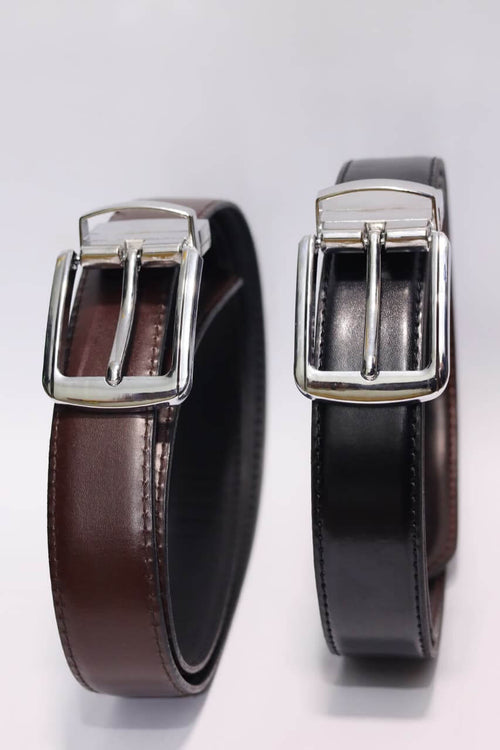 Two brown leather belts with silver buckles on a light gray background