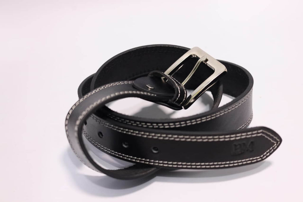 Black leather belt with silver buckle on a light gray background
