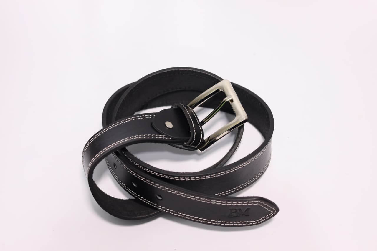 Black leather belt with silver buckle on a light gray background