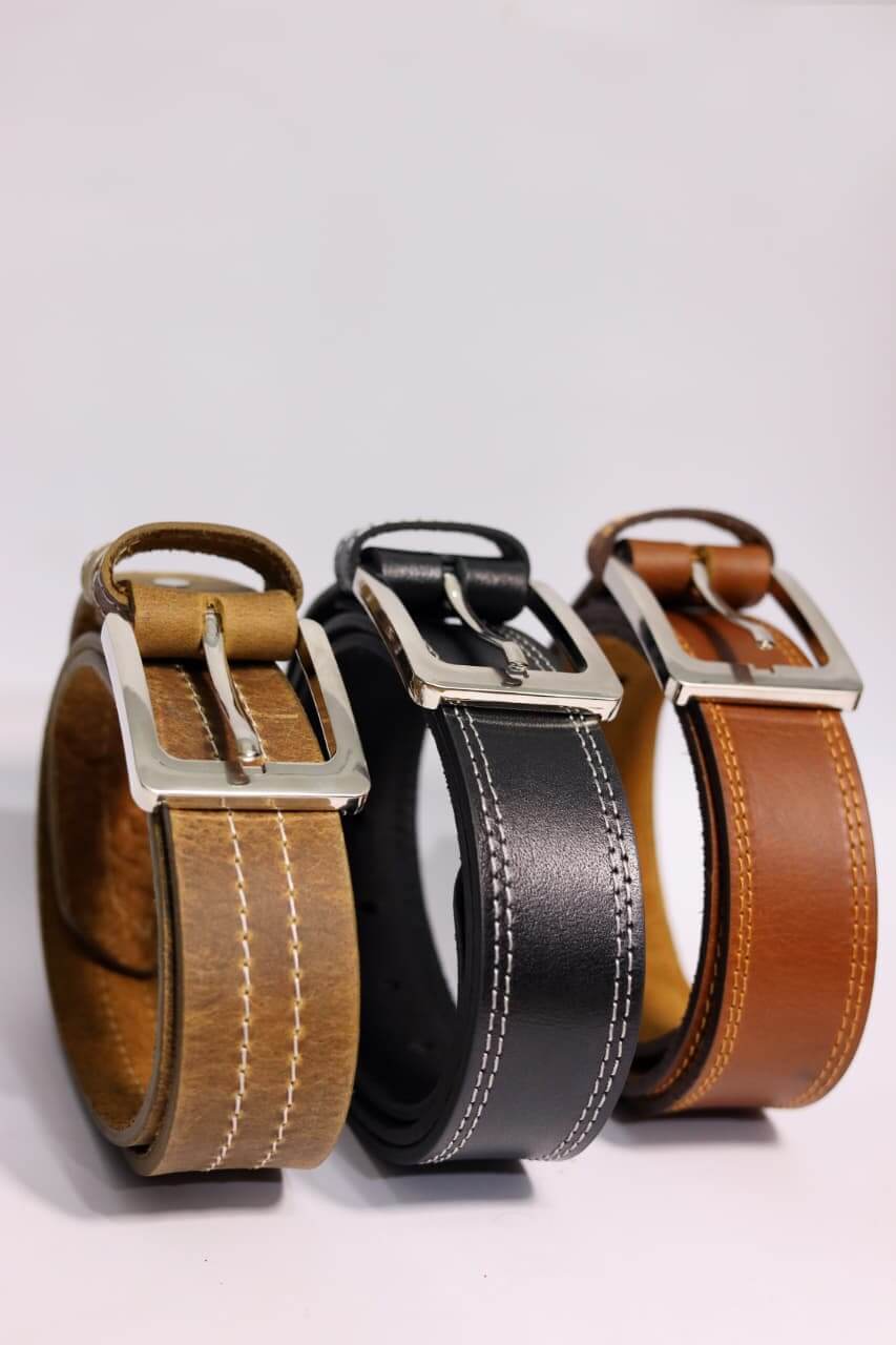 Three leather belts in brown, black, and tan with silver buckles on a light gray background.